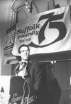 Suffolk University President Daniel H. Perlman (1980-1989) speaking at Law School Alumni Dinner during university's 75th anniversary, photograph, 12/08/1980