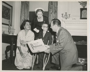 Mayor Robert F. Wagner presenting a proclamation from the American theatre wing to a young boy with forearm crutches