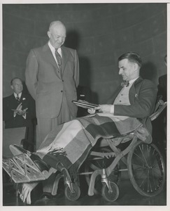 President Dwight D. Eisenhower presenting a plaque to an unidentified man in a wheelchair