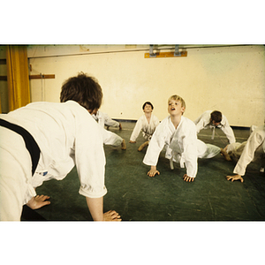 Students stretching on the ground during a martial arts class