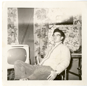 Hermenegildo Silva sitting in front of television