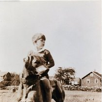 Stephen Stiles astride the dog statue at the farm circa 1933