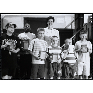 Heather Khan, a former news anchor, posing with six boys holding their awards at a Kiwanis Awards Night