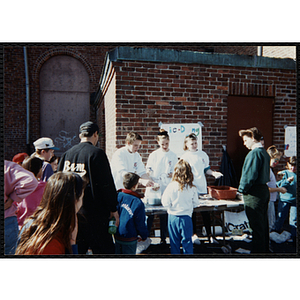 Children wait in line to tie-dye t-shirts at a carnival