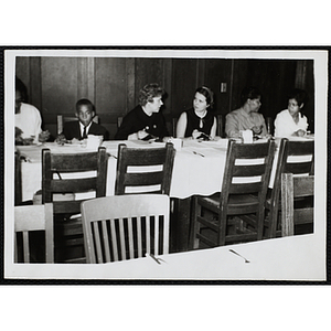 Women and a boys eat and converse during a Moms' Club banquet