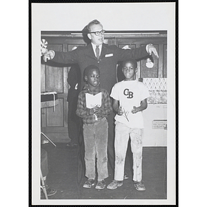 A man conducts as two boys sing during a Christmas event