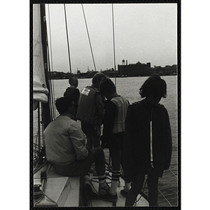 Four boys and a man occupy the deck of a sailboat in Boston Harbor