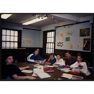 Children sit around a table with site coordinator Liz Cinquino and an unidentified man at the Tri-Club youth leadership event at the South Boston Clubhouse