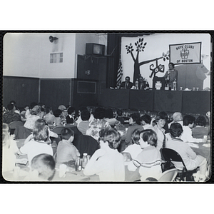 Children and adults seated around tables look to the stage during a Boys & Girls Club Awards Night