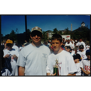 Executive Director Jerry Steimel poses with a boy holding a trophy during the Battle of Bunker Hill Road Race