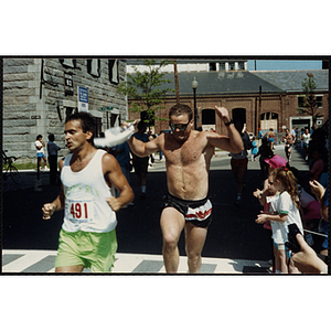 A man raises his arms as he crosses the finish line during the Battle of Bunker Hill Road Race