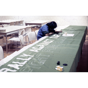 Painting a banner that reads, "Rally against Tufts expansion. Fight for elderly housing"