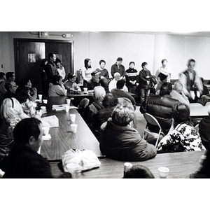 Association members sit, listening to announcements made at a meeting following Thanksgiving dinner
