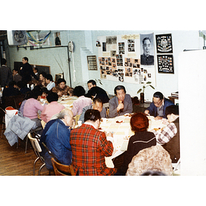 People sit at tables and enjoy a Thanksgiving dinner held by the Chinese Progressive Association