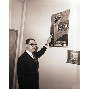 Professor Morton Rubin poses with a poster promoting his book