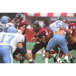 Northeastern football players running a play during a game