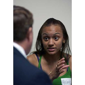 Melanie Arvajo gestures while conversing with a man at Torch Scholars Orientation