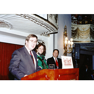 Three unidentified people at podium