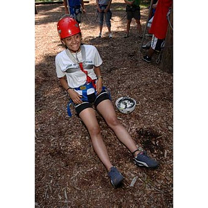 Melanie Arvajo sits on the ground at the Torch Scholars Project Adventure Ropes Course