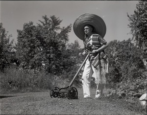 Richard Hallet, wearing sarape and sombrero, mowing the lawn