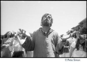 Bhagavan Das, arms raised with palms up, at Sonoma State University