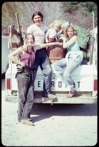 Joan Marr, Tony Mathews, and Karen Guilette (l. to r.) seated on the back of a pickup truck, Montague Farm Commune
