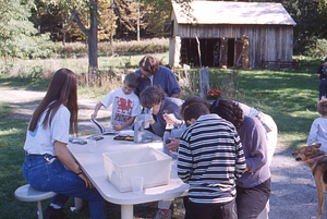 Hopkins Forest Fall Festival, 1999. 1. Emily Simpson (on right, Class of 2000) and people look at plants under dissecting microscope.