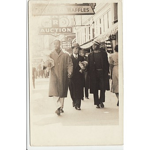 Three men walk down a busy street