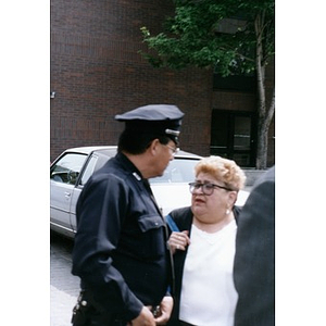 Policeman in uniform talking with a woman during Joe Kennedy's Villa Victoria visit.