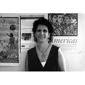 Portrait of a woman standing in front of a wall hung with posters.