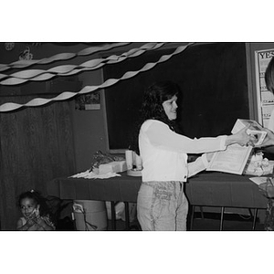 Woman accepting a certificate in a room decorated with streamers.
