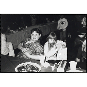 Two girls seated at a table display their awards during a Boys & Girls Club Awards Night