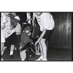 A girl touching a guitar as a young man holds it for her during the Boys and Girls Clubs of Boston 100th Anniversary Celebration event at the Charlestown Boys and Girls Clubhouse