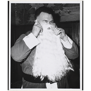 Santa Claus puts on his beard