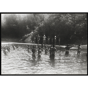 A group of youth hold hands near the swimming dock