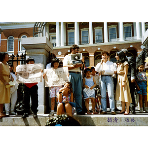 Demonstrators listen to an Asian woman speak in favor of bilingual education in schools during a rally at the Massachusetts State House