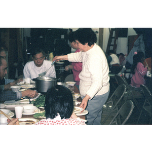 Woman spooning out food at a Chinese Progressive Association dinner