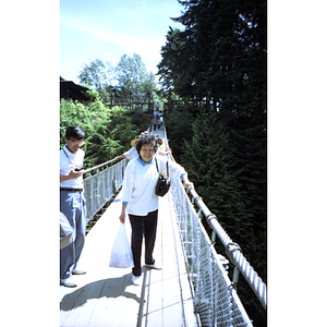 Chinese Progressive Association member walks across the Capilano Suspension Bridge in British Columbia