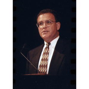 Comptroller Bill Kneeland speaks at podium during a General University Meeting