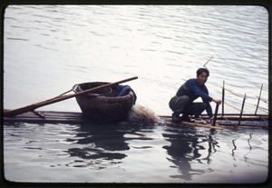 Fisherman on bamboo boat