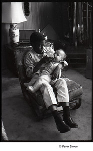 Party at Jackie Robinson's house: David Robinson feeding a baby with a  bottle - Digital Commonwealth