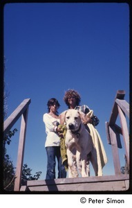 Peter Simon (right), labrador retriever, and unidentified woman at the top a step of steps, Tree Frog Farm commune