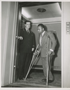 Elevator operator and man on crutches