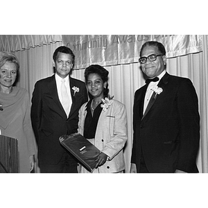 Carmen Pola stands with two men and a woman at the Action for Boston Community Development Community Awards Dinner on 26 October 1984