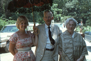 Pam Art, Arthur E.. and Ella M. Rosenburg under 19th C. parasol at Moon Barn Raising at entrance to Hopkins Forest on 2 August 1975.