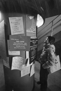A Suffolk University student reads flyers in the Fenton Building (28 Derne Street)
