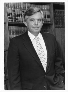 Suffolk University President David J. Sargent (1989-2010) in front of bookshelves
