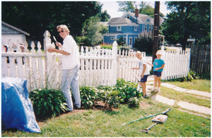 Kathleen and neighbors painting the picket fence