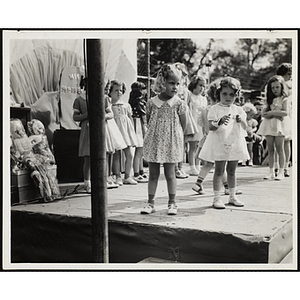 Participants standing on the outdoor stage during a Boys' Club Little Sister Contest