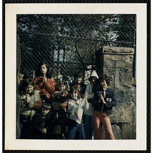 Ten boys and girls from the South Boston Boys' Club standing outside, putting their hands together